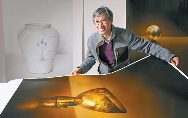 The renowned photographer Koo Bohnchang shows a photo from his new “Gold” series at his studio. Photo© PARK SANG-MOON