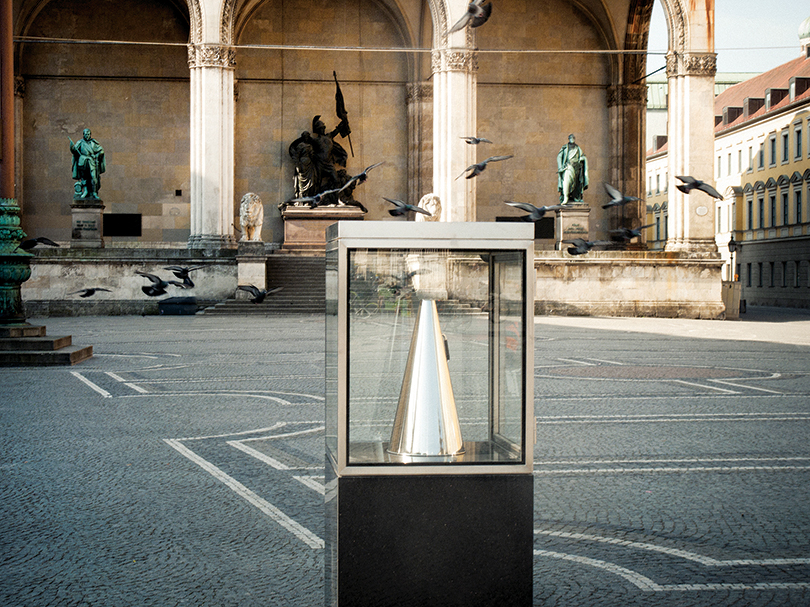 It's Never Too Late to Say Sorry 2011 Plinth: granite; vitrine: steel, lock, safety glass; megaphone: polished aluminum 160×70×70cm Courtesy: Sculpture International Rotterdam Photo by: Jannes Linders (Rotterdam), Toni Prikryil (Aspen), Leonie Felle (Munich)  