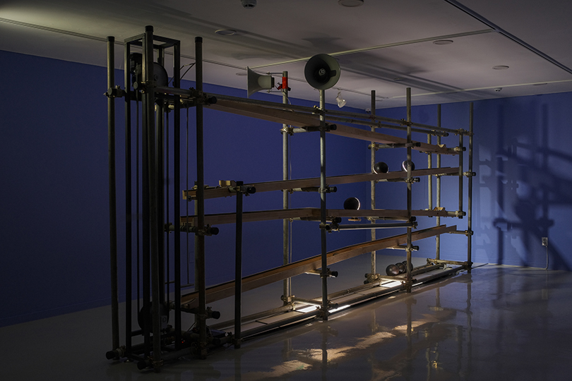 Trap of Balance #1; High-voice, low-voice, 2021, sound installation, mixed media ; motor, sound-ball module, wood, scaffold, lighting, speaker, 5,500x650x3,400mm